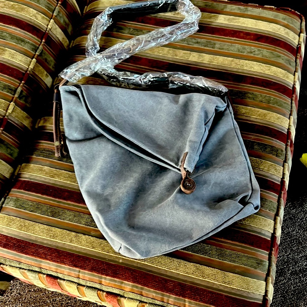 New without tags…Gray shoulder bag. 12” X 14” inside and outside pockets.